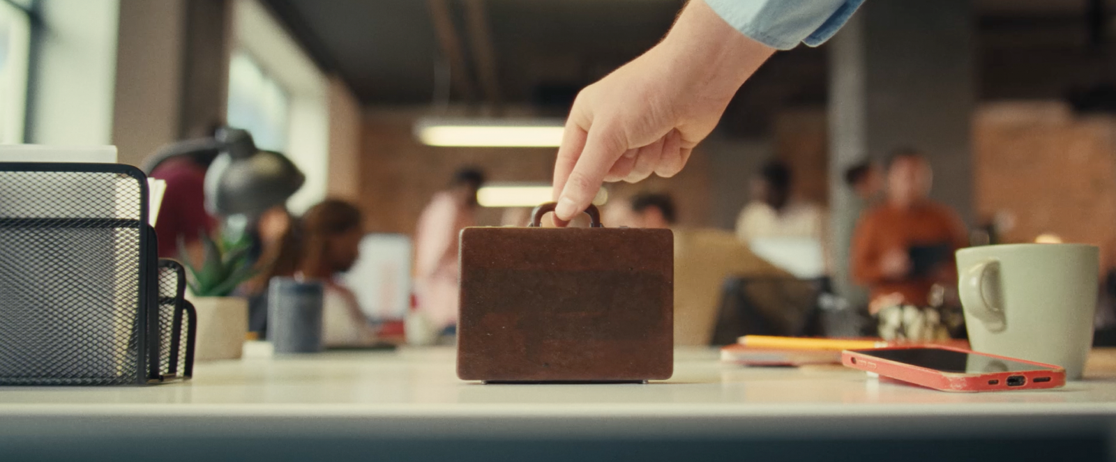 A tiny briefcase symbolizes how Dayforce shrinks the weight of work