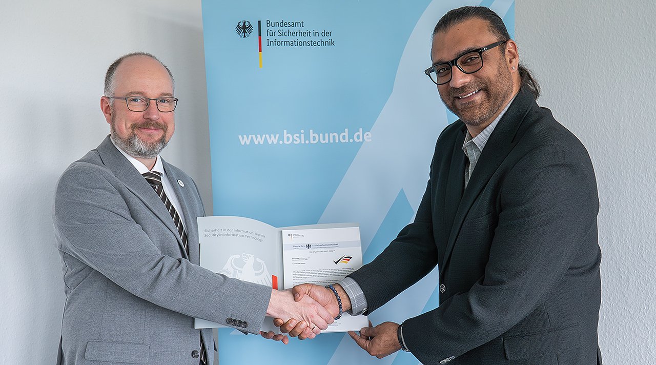 Fabian Hodouschek, Head of Certification at the Federal Office for Information Security (BSI), presents the BSI NESAS certificate to Omar Shahdad
